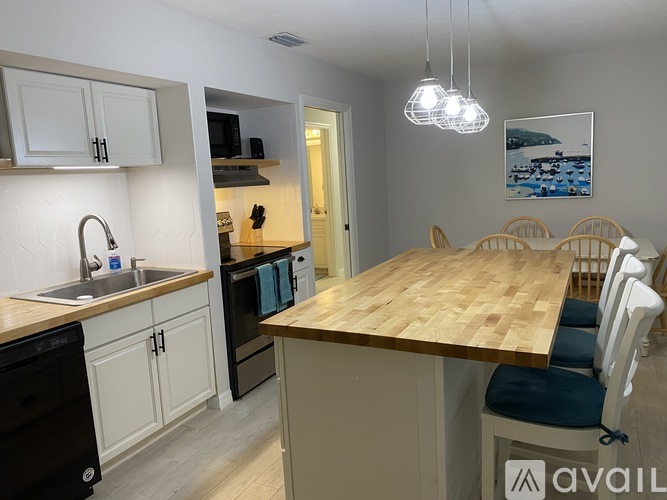 A kitchen with a wooden table and chairs.