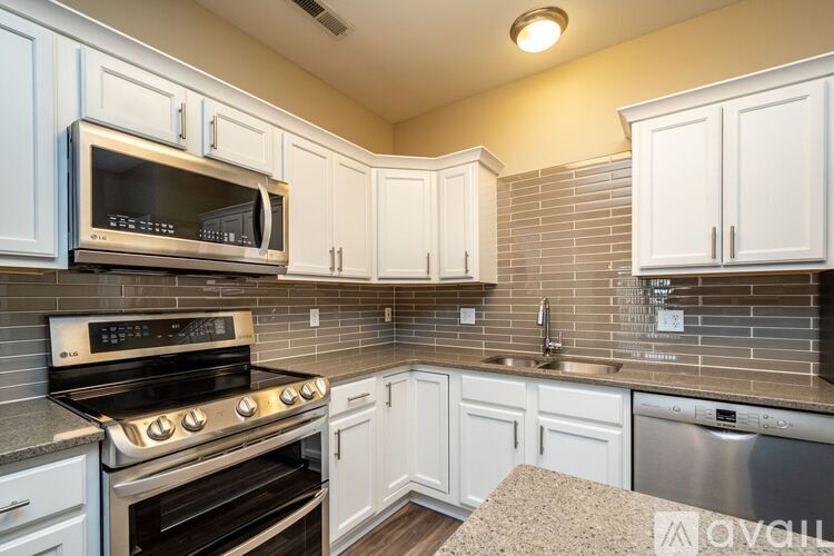 A kitchen with white cabinets and a stainless steel oven.