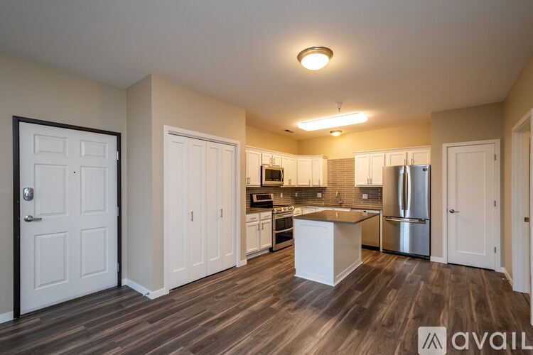 A kitchen with white cabinets and a wooden floor.