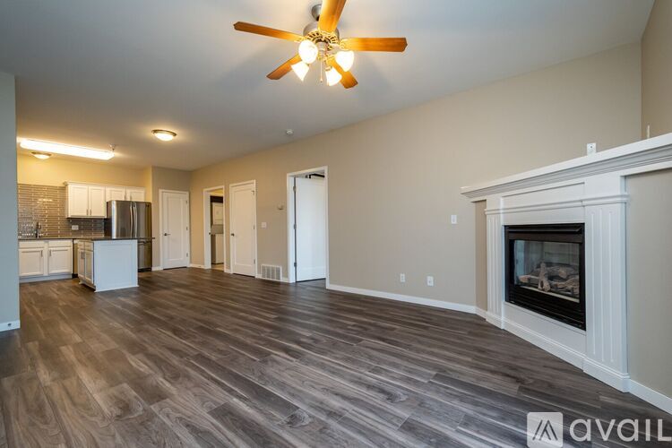 A spacious living room with a fireplace and a ceiling fan.
