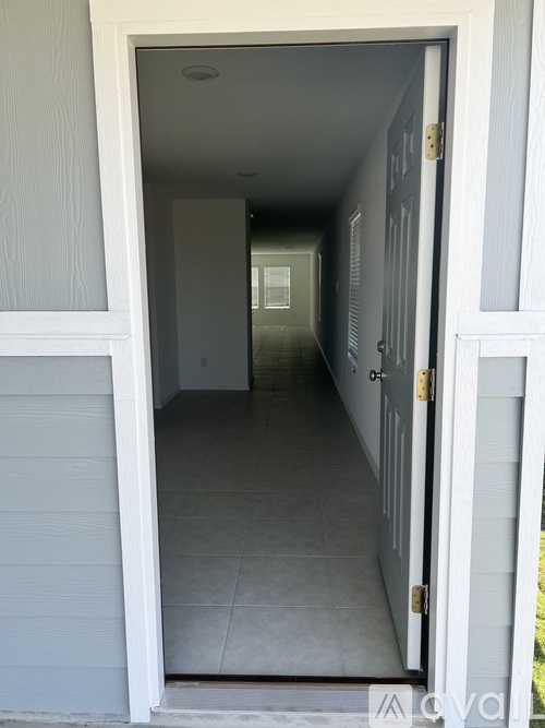 A hallway with a white door and a white wall.