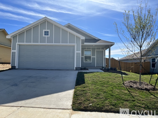 A two-car garage with a white door is attached to a house.