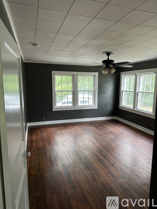 A room with wooden floors and a ceiling fan.