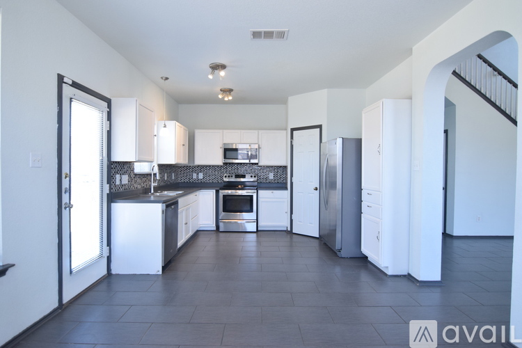 A kitchen with white appliances and cabinets is available for rent.