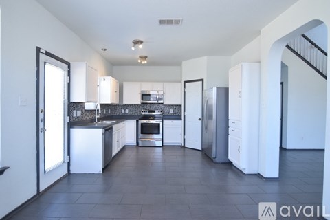 A kitchen with white appliances and cabinets is available for rent.