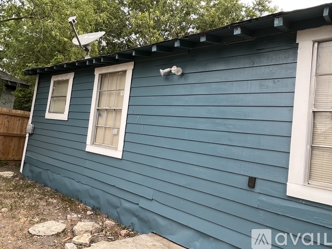 A blue house with a satellite dish on the roof.