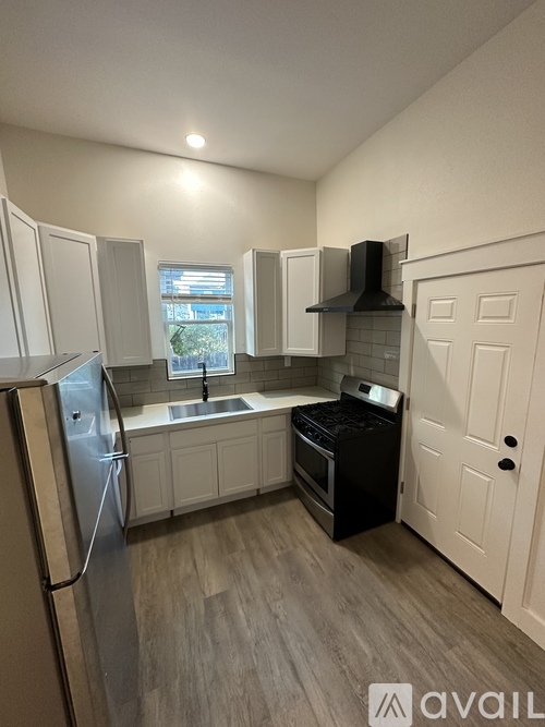 A kitchen with white cabinets and a black stove top oven.