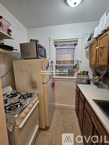 A dirty kitchen with a stove and a refrigerator.