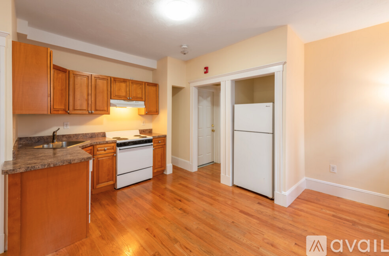 A kitchen with wooden cabinets and a white fridge.