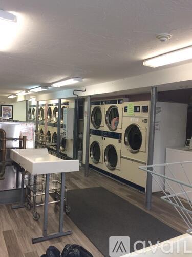 A laundromat with a row of washers and dryers.