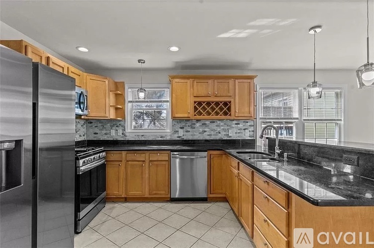 A kitchen with wooden cabinets and a black countertop.