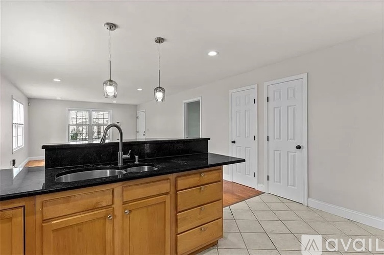 A kitchen with wooden cabinets and a black countertop.