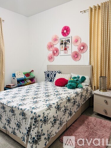 A bedroom with a floral bedspread and a white headboard.