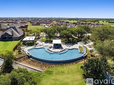 A large swimming pool surrounded by a wooden fence and a grassy area.