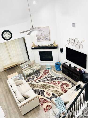 A living room with a white couch and a patterned rug.