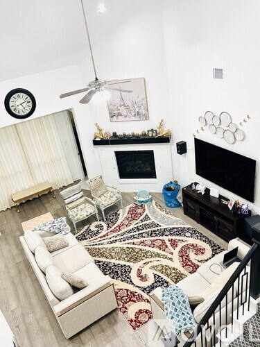 A living room with a white couch and a patterned rug.