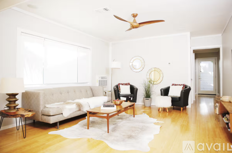 A living room with a white couch, a wooden coffee table, and a rug on the floor.