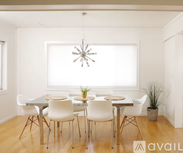 A dining room with a white table and chairs.