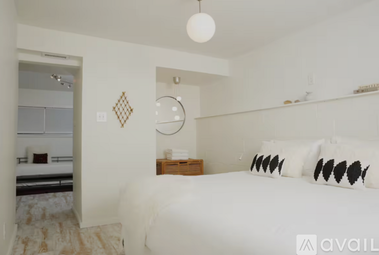 A bedroom with a large bed and a mirror on the wall.