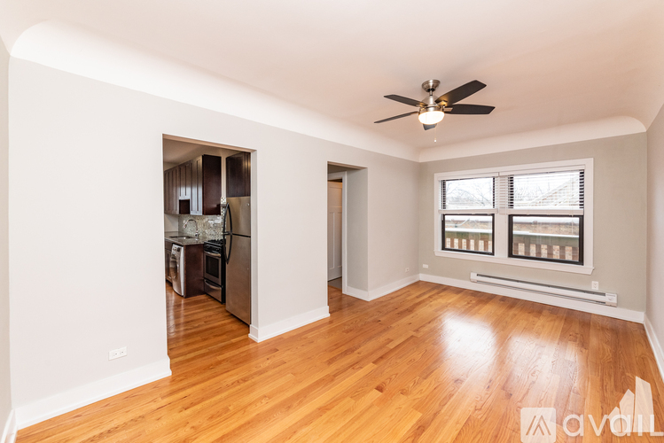 A room with a ceiling fan and wooden floors.