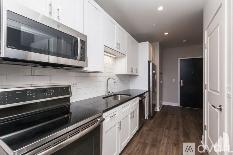A modern kitchen with white cabinets and stainless steel appliances.