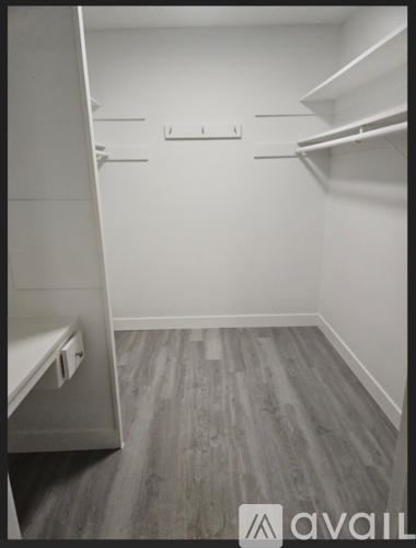 A small walk-in closet with a built-in bench and shelves.