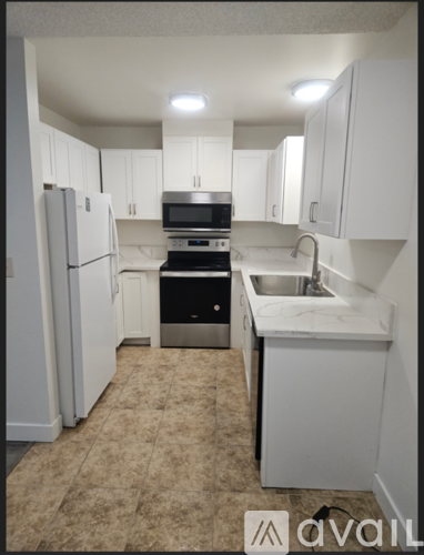 A kitchen with white cabinets and appliances.