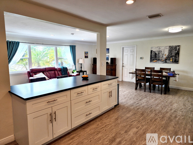 A kitchen with white cabinets and a black countertop.