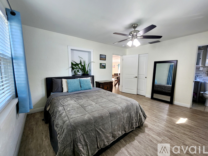A bedroom with a large bed and a ceiling fan.