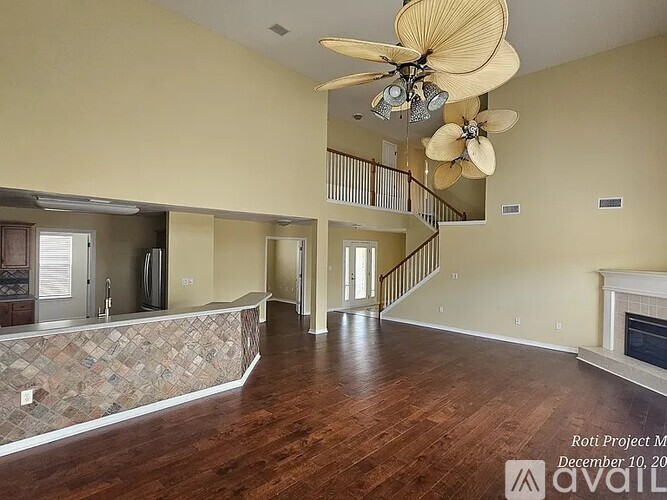 A large open living room with a staircase and a fireplace.