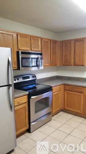A kitchen with wooden cabinets and stainless steel appliances.