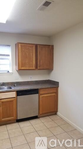 A kitchen with wooden cabinets and a dishwasher.