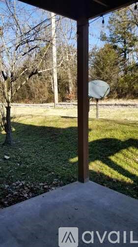 A view from inside a building looking out to a grassy area with a basketball hoop.