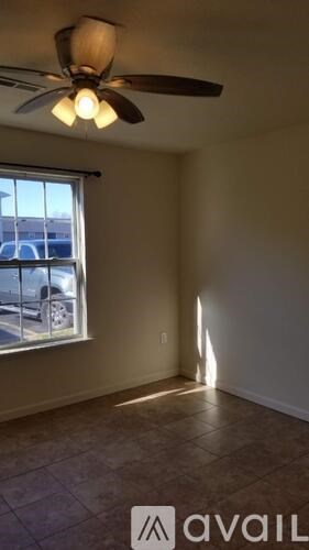 A room with a ceiling fan and a window.