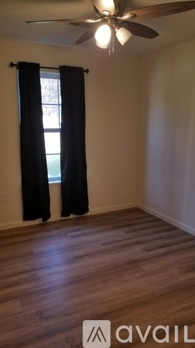 A room with a window and a ceiling fan.