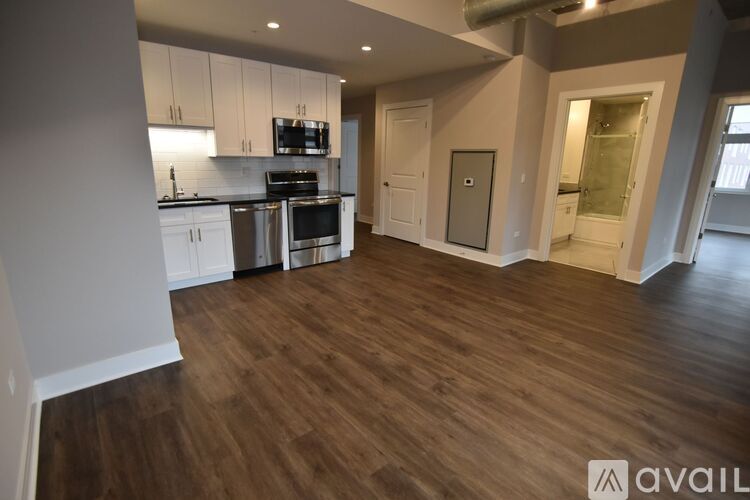 A kitchen with white cabinets and a wooden floor.