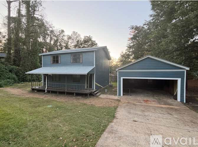 A blue house with a garage is available for rent.