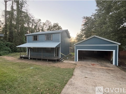 A blue house with a garage is available for rent.