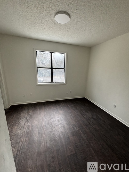 A room with a window and wooden flooring.