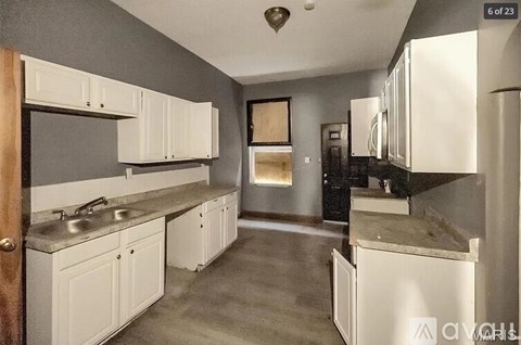 A kitchen with white cabinets and a countertop.