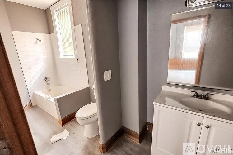 A bathroom with a white toilet, a white sink, and a white bathtub.