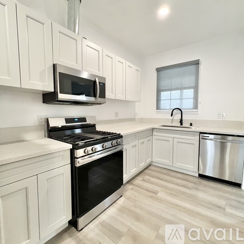A kitchen with white cabinets and stainless steel appliances.