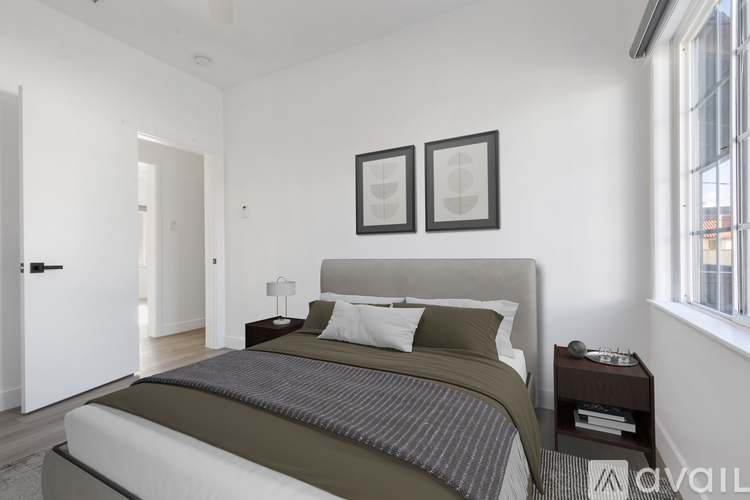 A bedroom with a large bed and two picture frames on the wall.