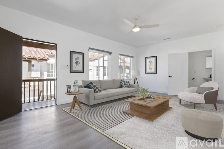 A living room with a white couch, a wooden coffee table, and a ceiling fan.