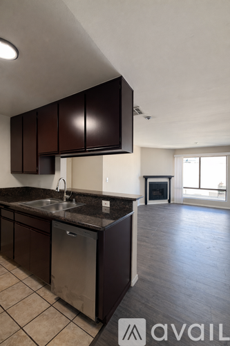 A kitchen with dark brown cabinets and a stainless steel dishwasher.