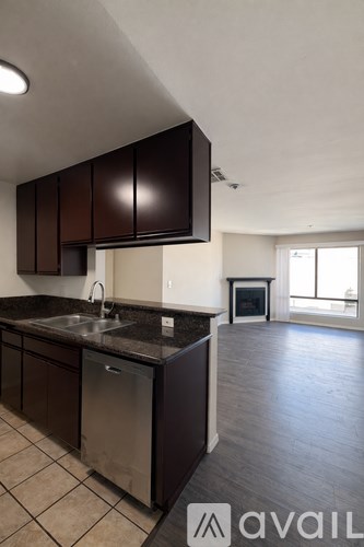 A kitchen with dark brown cabinets and a stainless steel dishwasher.
