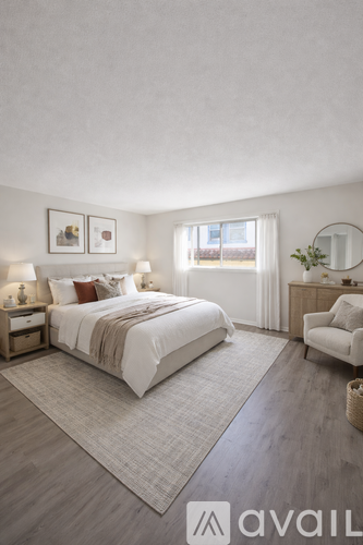A bedroom with a large bed, a chair, and a mirror.