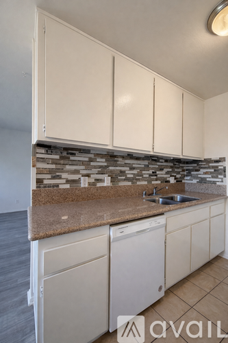 A kitchen with white cabinets and a granite countertop.
