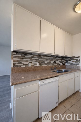 A kitchen with white cabinets and a granite countertop.