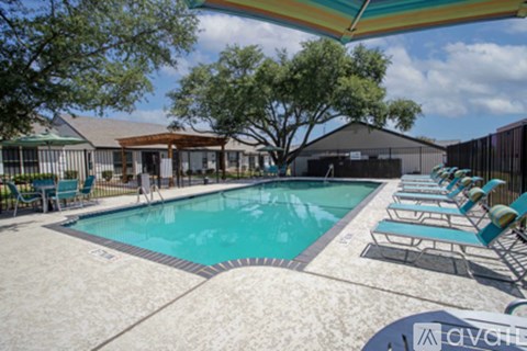 A pool with chairs around it and a building in the background.